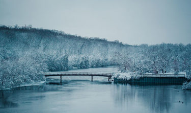 A footbridge in a winter landscape with snow and ice